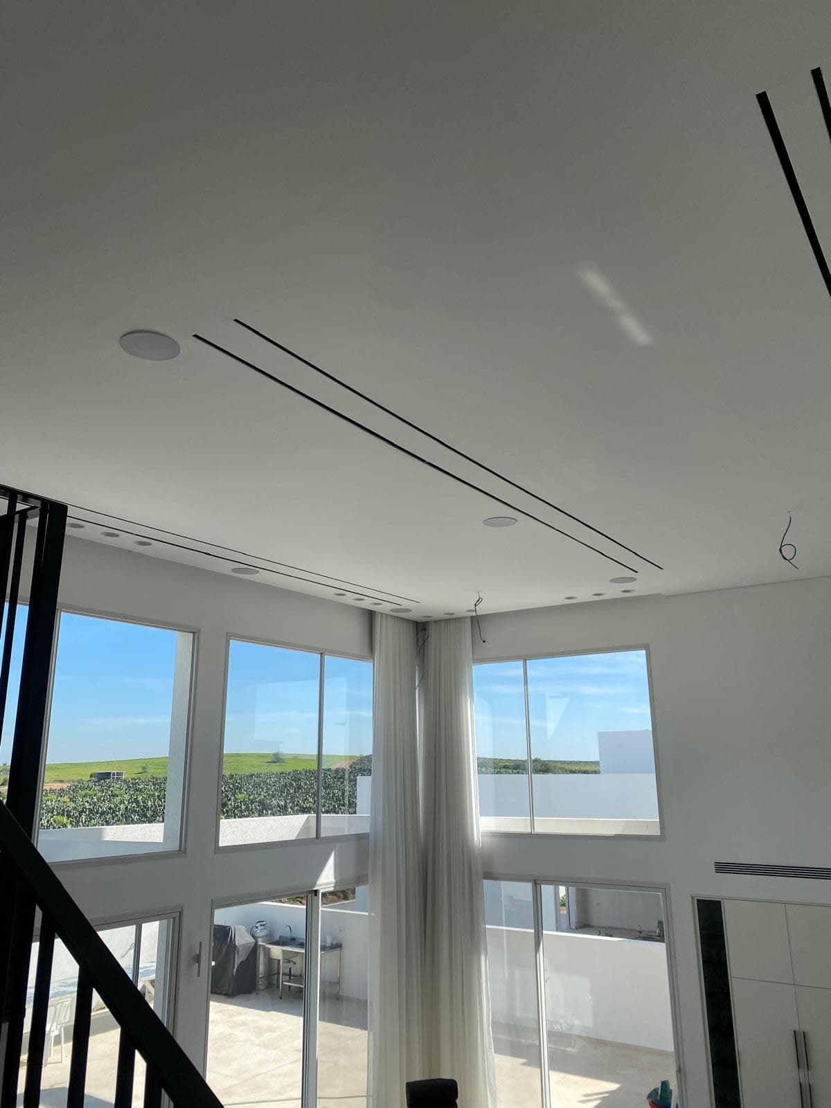 סלון וילה בלהבים עם חלונות פנורמיים ומערכת VRF בתקרה